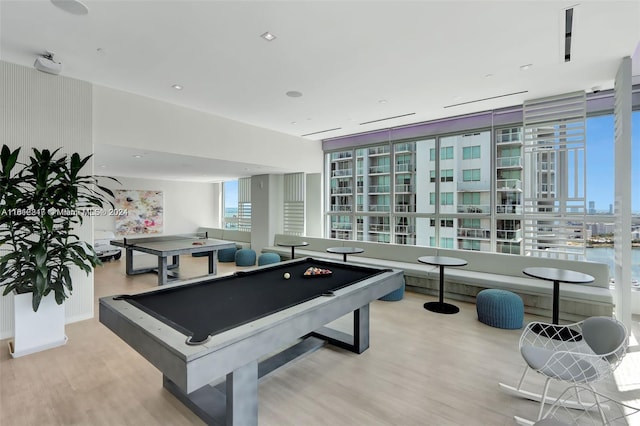 game room with hardwood / wood-style flooring, a water view, pool table, and expansive windows