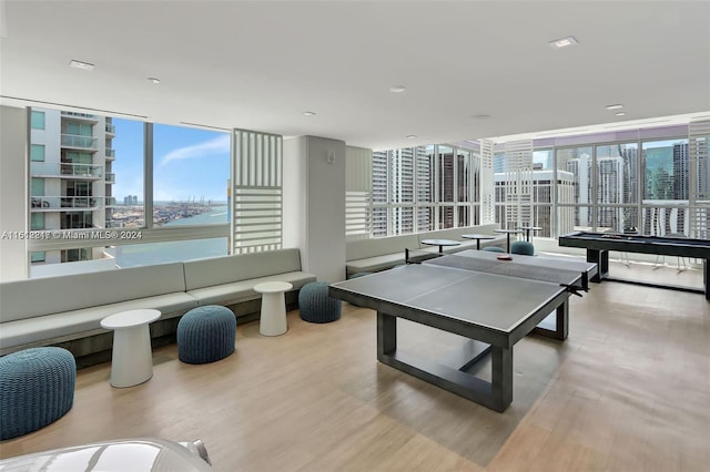 rec room featuring light hardwood / wood-style flooring and a water view