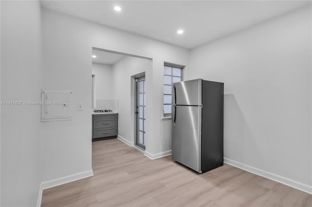 kitchen featuring light wood-type flooring, stainless steel fridge, and gray cabinetry