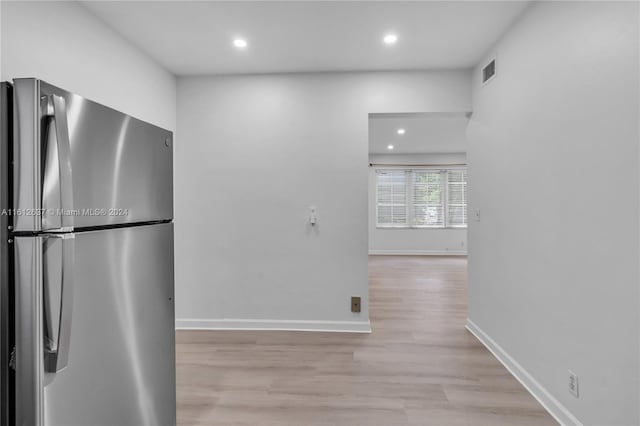 kitchen featuring stainless steel fridge and light hardwood / wood-style floors