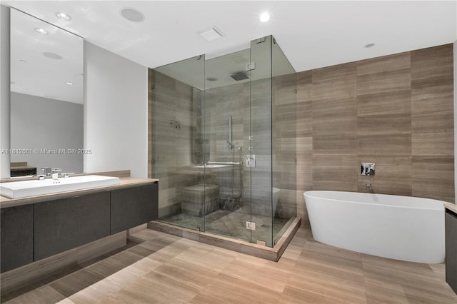 bathroom with tile patterned flooring, plus walk in shower, and vanity