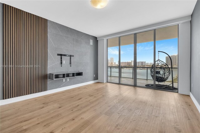 unfurnished living room featuring light hardwood / wood-style floors and floor to ceiling windows