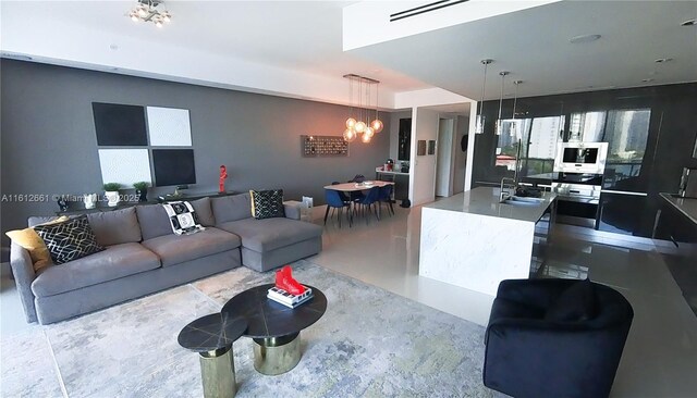 living room with a notable chandelier and sink