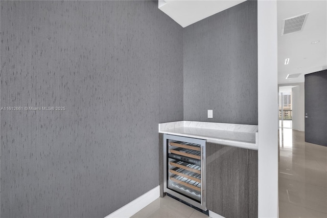 bar featuring beverage cooler and light tile patterned floors