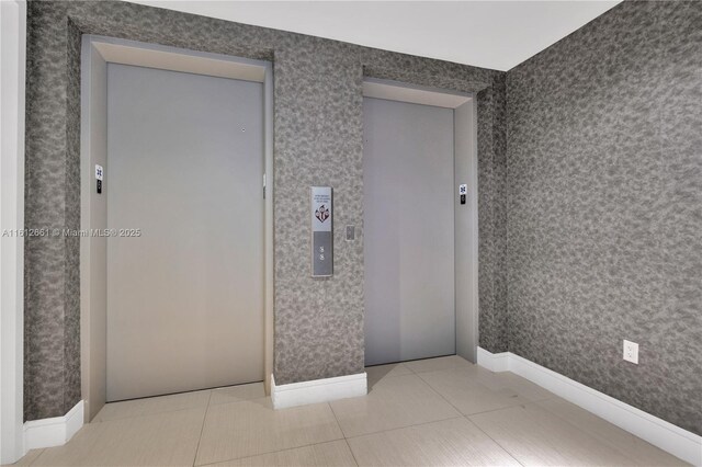 unfurnished bedroom with elevator and tile patterned flooring