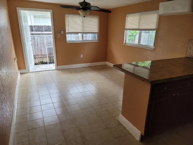 interior space featuring an AC wall unit, ceiling fan, and light tile patterned floors