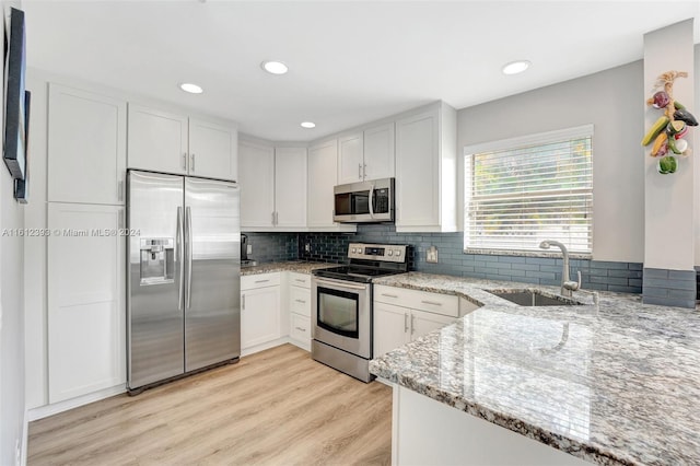 kitchen featuring stainless steel appliances, sink, light hardwood / wood-style floors, and white cabinets