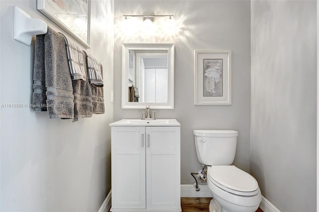 bathroom featuring hardwood / wood-style floors, vanity, and toilet