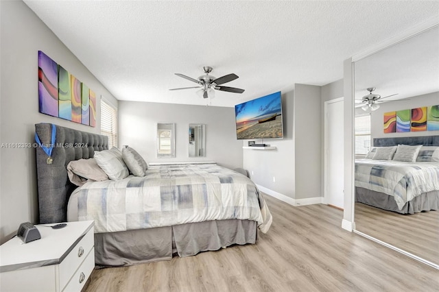 bedroom featuring ceiling fan, a textured ceiling, and light wood-type flooring