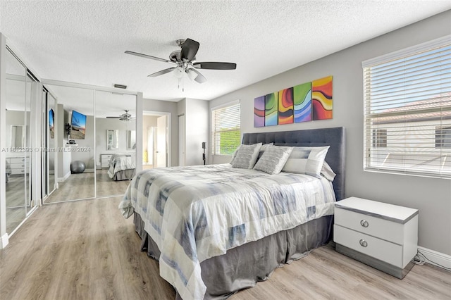 bedroom featuring a textured ceiling, ceiling fan, and light hardwood / wood-style flooring