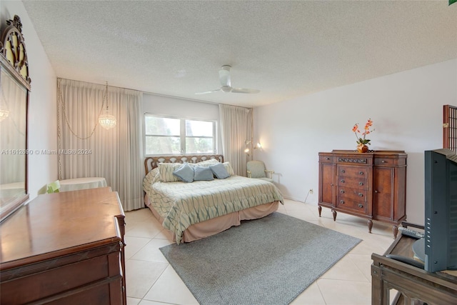 bedroom featuring a textured ceiling, light tile flooring, and ceiling fan