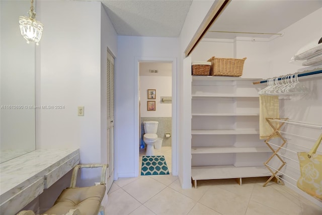 walk in closet featuring light tile flooring