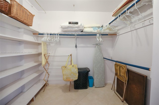 walk in closet with light tile floors