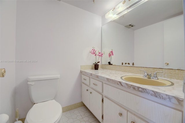 bathroom featuring tile flooring, toilet, and large vanity