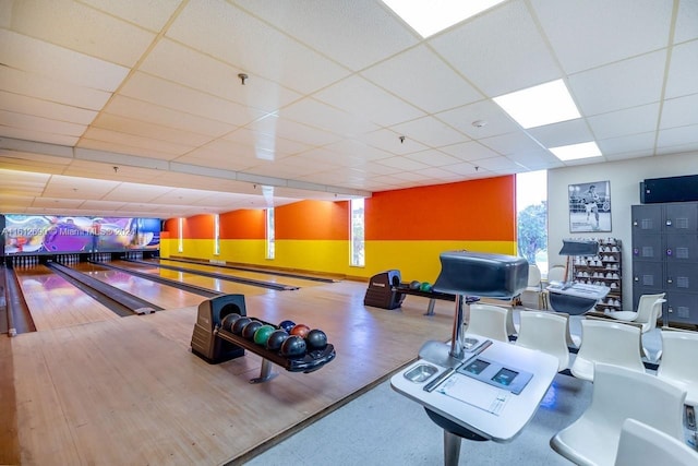 playroom featuring a bowling alley, a wealth of natural light, and a paneled ceiling