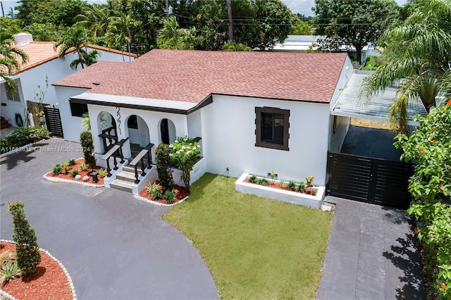 mediterranean / spanish-style house with covered porch and a front lawn