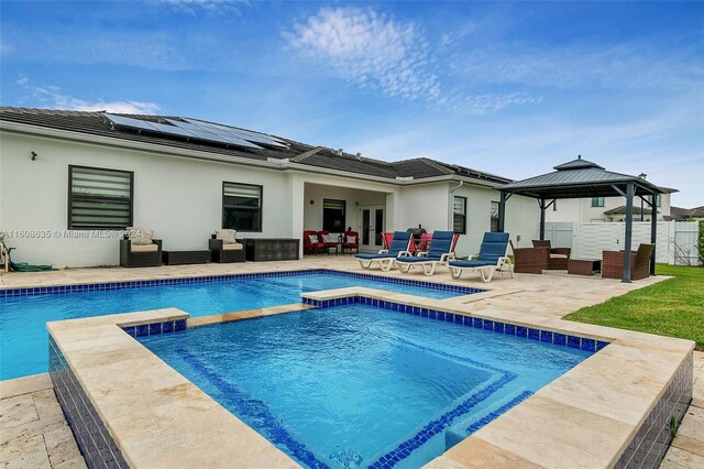 exterior space with a patio area, solar panels, a gazebo, a pool with hot tub, and an outdoor living space