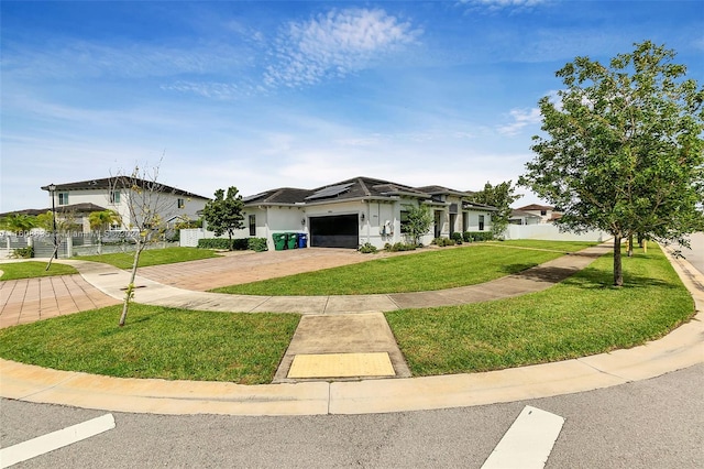 view of front facade featuring a garage, fence, a front lawn, and solar panels