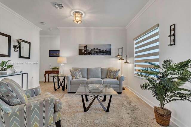 living room featuring ornamental molding and light wood-type flooring