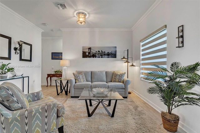 living area with ornamental molding, light wood-style flooring, and visible vents