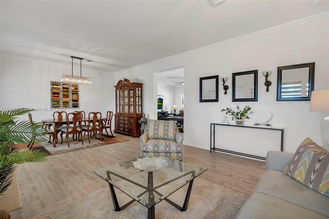 living room featuring ornamental molding, hardwood / wood-style flooring, and a chandelier