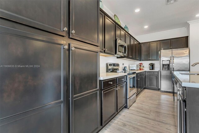 kitchen with crown molding, light wood-type flooring, stainless steel appliances, dark brown cabinetry, and sink