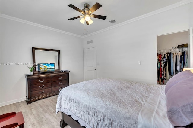 bedroom featuring light wood-style floors, visible vents, and crown molding