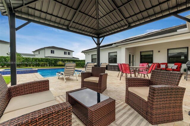 exterior space featuring outdoor lounge area, a gazebo, and a fenced in pool