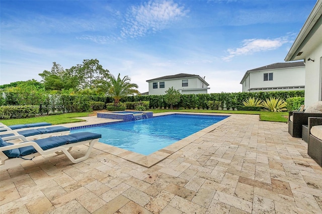 view of swimming pool featuring a pool with connected hot tub, a patio area, and a fenced backyard