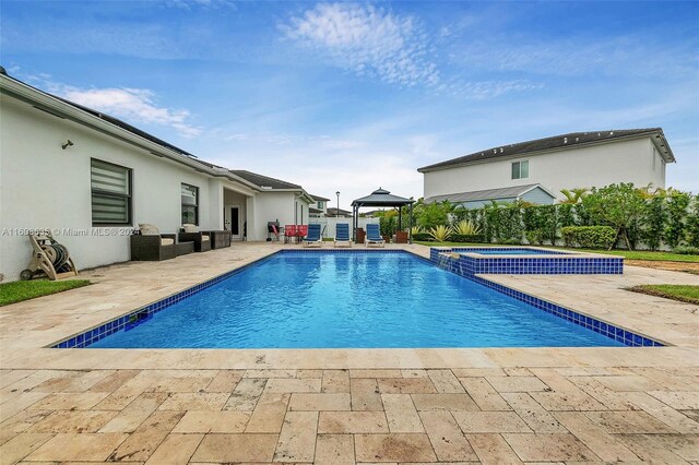 view of swimming pool featuring a patio area and an in ground hot tub