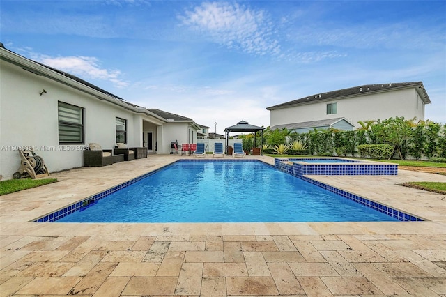 view of pool featuring a patio area, a pool with connected hot tub, and a gazebo