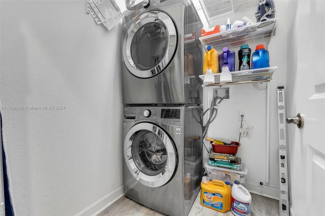 clothes washing area with stacked washer / dryer, light hardwood / wood-style floors, and washer hookup