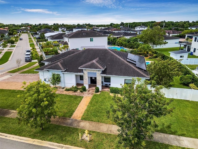 ranch-style house with a residential view, fence, and a tiled roof