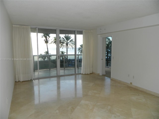 unfurnished room featuring floor to ceiling windows and light tile patterned flooring