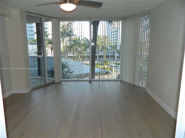 unfurnished room featuring floor to ceiling windows, a healthy amount of sunlight, hardwood / wood-style floors, and ceiling fan