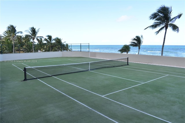 view of tennis court with a water view