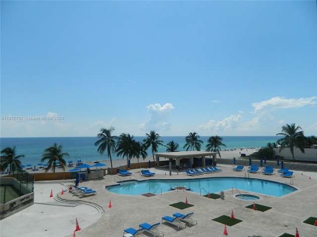 view of swimming pool with a patio and a water view