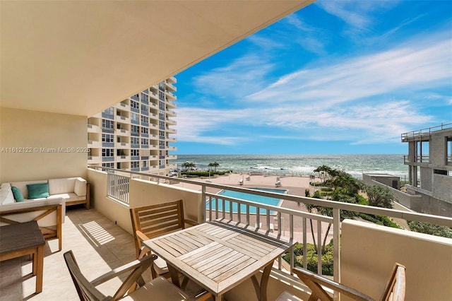 balcony featuring a view of the beach and a water view