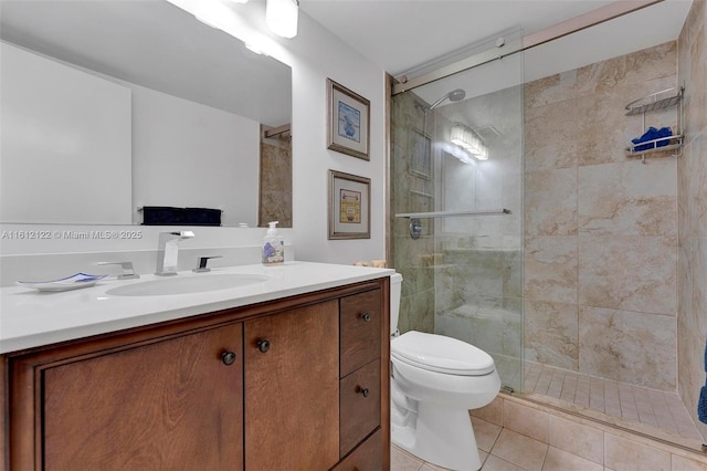 bathroom with tile patterned flooring, vanity, toilet, and walk in shower