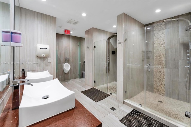 bathroom with sink, an enclosed shower, tile walls, and tile patterned flooring