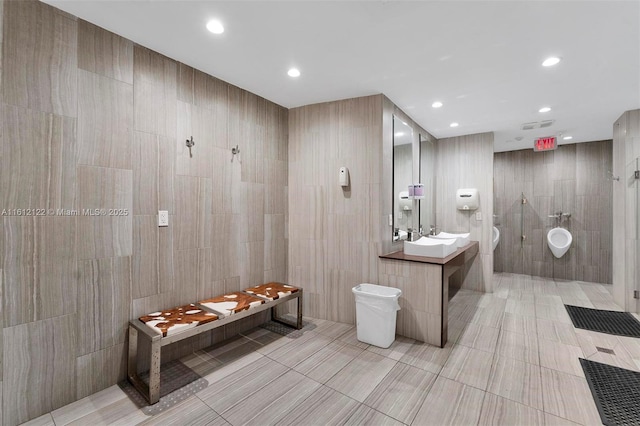 bathroom with vanity, a shower, toilet, and tile walls