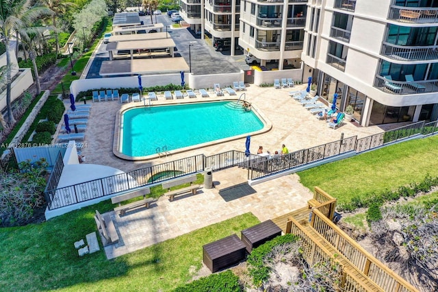 view of pool featuring a patio and a yard