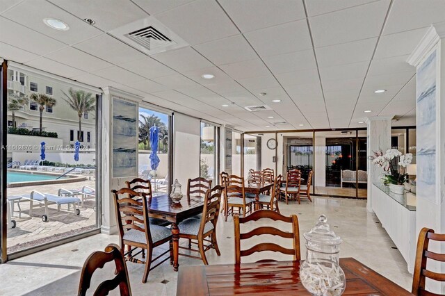 dining room featuring light tile patterned floors and a wall of windows