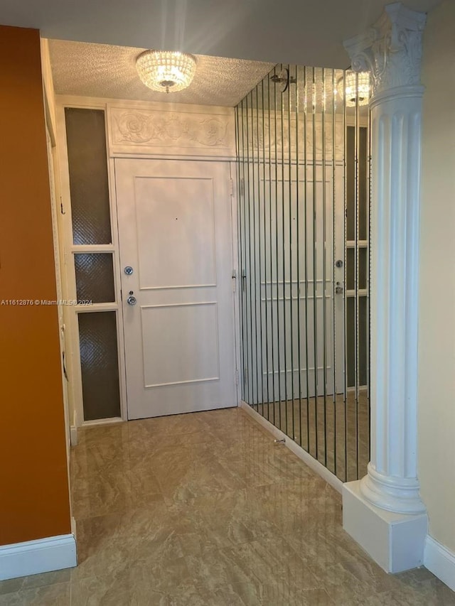 hallway featuring ornate columns, a textured ceiling, and tile patterned flooring