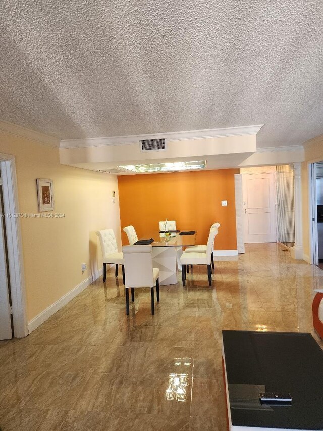 dining area with a textured ceiling and tile patterned flooring