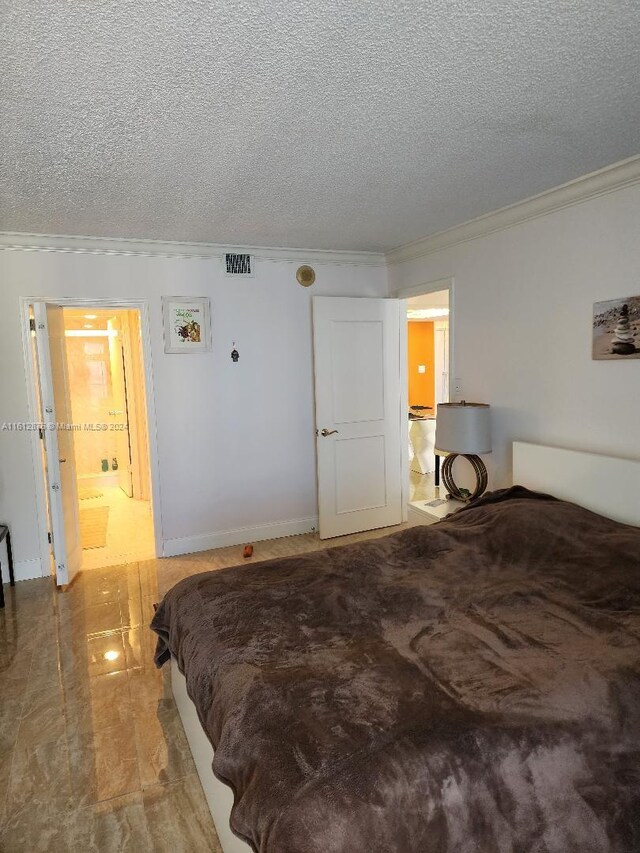 tiled bedroom with crown molding, ensuite bath, and a textured ceiling