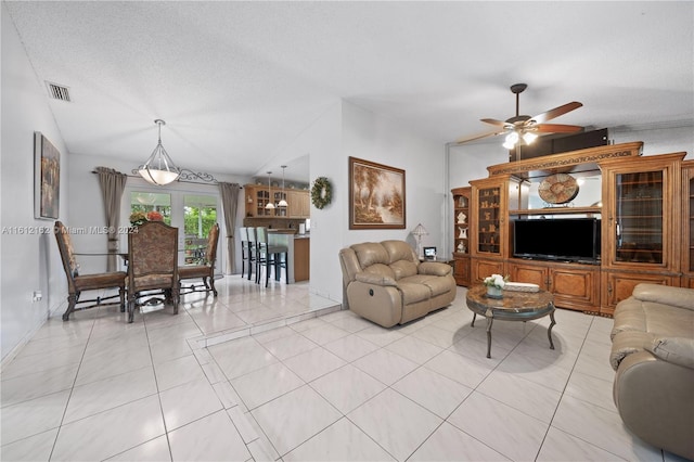 living room featuring light tile patterned floors, a textured ceiling, ceiling fan, and lofted ceiling