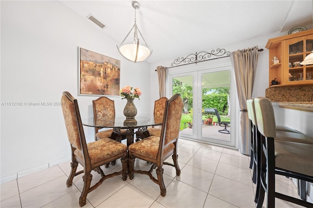 dining area with light tile patterned floors and lofted ceiling