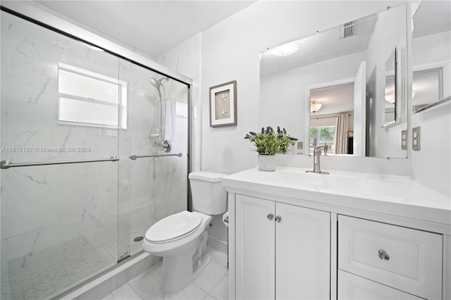 bathroom with vanity, toilet, and a shower with door