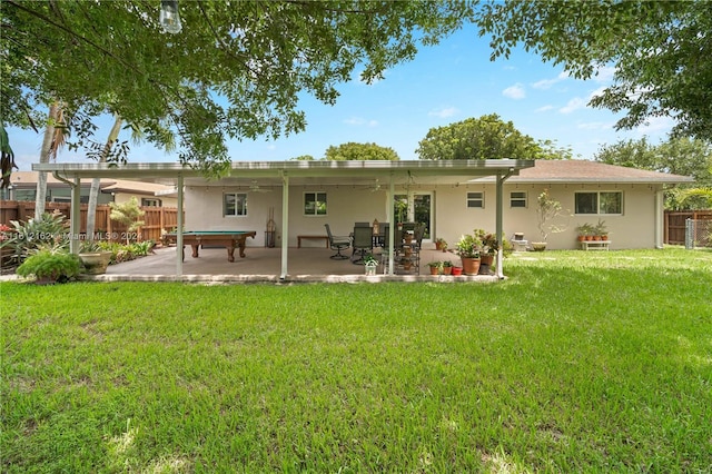 back of property with a yard and a patio area